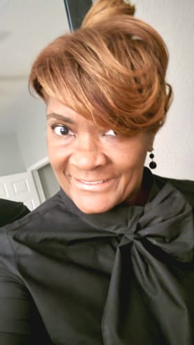 Close-up of a reviewer wearing the black shirt dress, highlighting the elegant stand collar bow.