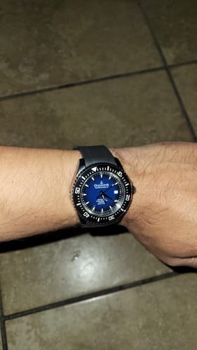 Customer wearing the Oceaneva Deep Marine Explorer VI watch with a blue burst dial and black strap on their wrist.