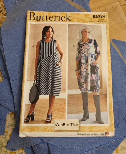 Reviewer making a dress with the Plain Blue Chambray Denim Fabric, showing the cut pieces and pattern envelope.