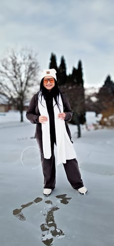 Reviewer smiling while wearing the stylish cream Bradie Scarf in a snowy landscape.