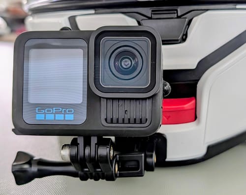 Customer's close-up of a GoPro on the Shoei Neotec 3 Camera Mount, attached to the chin of a white helmet.