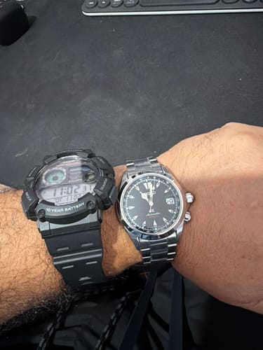 Cliente comparando el tamaño de su reloj Seiko Black Alpinist en la muñeca junto a otro reloj.