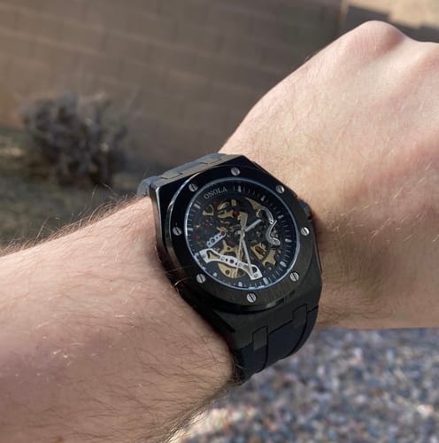 Reviewer's close-up of the black Lucky Fours® Prince Oak watch with a skeleton dial on their wrist.