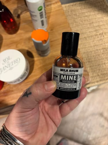 Recensore tiene in mano la piccola boccetta del profumo MILK RHUM.