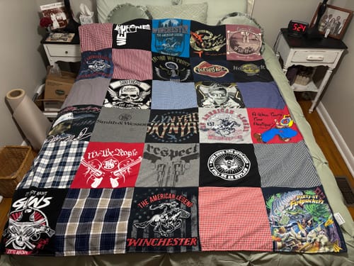 Customer's memorial Premium T-Shirt Quilt made from various t-shirts and plaid shirts, spread on a bed.