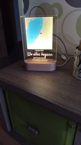 Kunde zeigt das beleuchtete personalisierte Nachtlicht "Unser Ereignis", das auf einem Nachttisch steht.