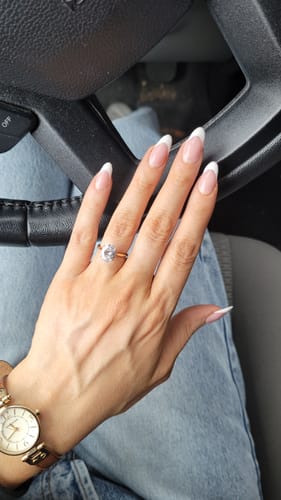Customer's hand on a steering wheel, wearing the beautiful Oval Solitaire Ring.