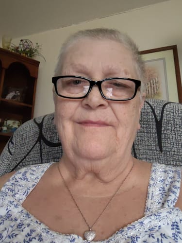 Reviewer smiling while wearing the Forever In My Heart Urn Necklace with a silver heart pendant.