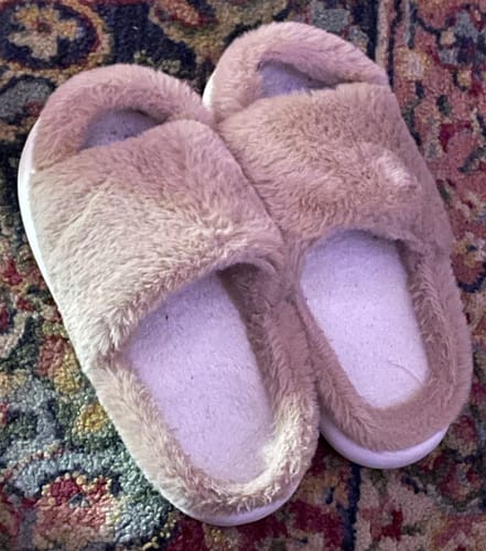 Customer's fuzzy, tan Cloud Slides - Fuzzy Fur slippers resting on a patterned carpet.
