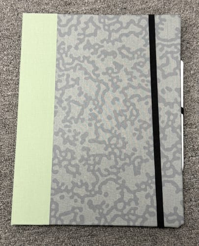 Customer's closed custom book-style iPad case with a light green spine and a grey patterned cover.