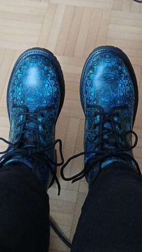 Une cliente montre ses bottes Thalassa bleues, mettant en valeur leur motif détaillé.