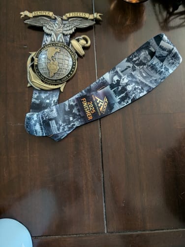 Customer's image showing a marathon finisher's medal and ribbon on a wooden table.
