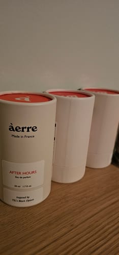 Customer's After Hours perfume in three white tubes on a wooden surface.
