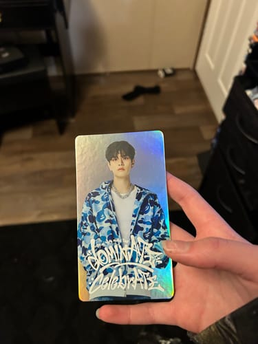 Customer holding a holographic photocard from the STRAY KIDS Special Ticket Set, showing a member in a blue camo jacket.