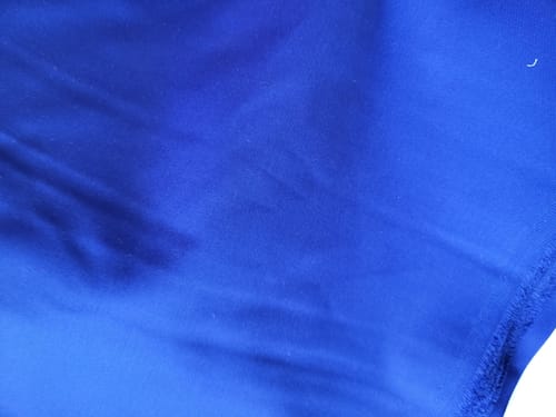 Close-up: Customer's bright blue Heavy Suiting Panama fabric showing its smooth texture.