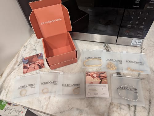 Customer showing the WaterProof Jewelry Bundle with its open gift box and seven individually packaged jewelry items.