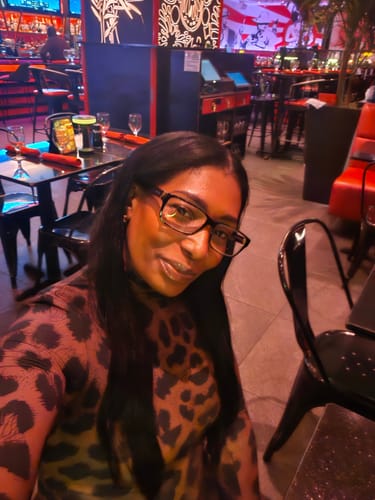 Close-up of a customer in the leopard print Naked Print Jumpsuit, highlighting the sleek turtleneck collar.