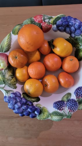 Ein Kunde zeigt die Vielfalt des Bio Clementinen-Mix in einer dekorativen Obstschale.