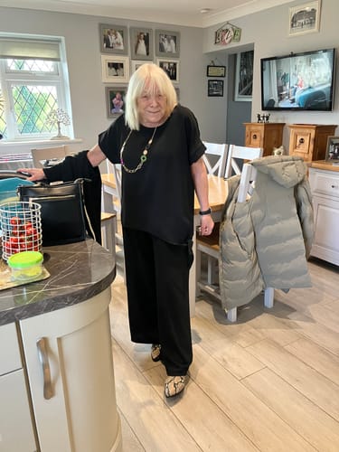 Reviewer standing in a kitchen wearing the comfortable Eleanor Black Side Knot Set.