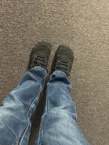 Customer's perspective looking down at their gray Will II Winter Barefoot Shoes worn with blue jeans.
