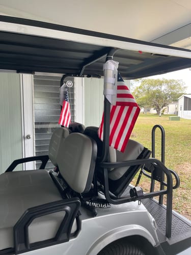 Customer's two American Flags attached to the back of a golf cart, waving lightly in the breeze.