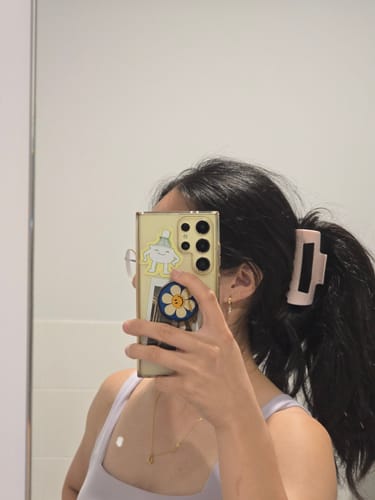 Reviewer with thick, dark hair pulled back into a ponytail with a light pink cloud clip.