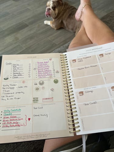 Reviewer sitting with their open 2026 Signature Planner, showing handwritten goals and stickers on the pages.