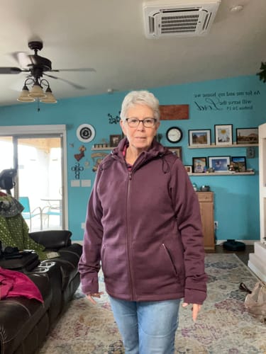 Reviewer demonstrates the long sleeves of the Grape Harvest Cubby Hooded Sweatshirt, with one cuff rolled and one down.