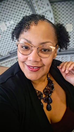 Reviewer showing shiny curls and new hair growth on their edges after using the Stimulating Scalp and Hair Balm.