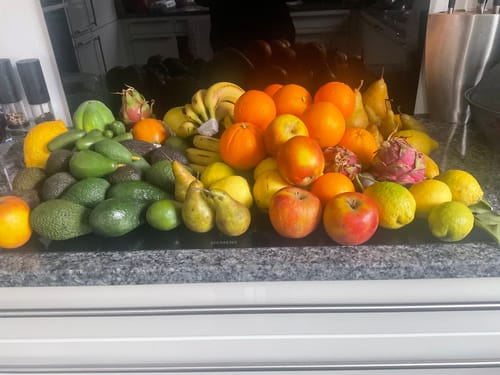 Ein Kunde zeigt den großen, vielfältigen Inhalt der Überraschungs-Box auf einer Küchentheke.