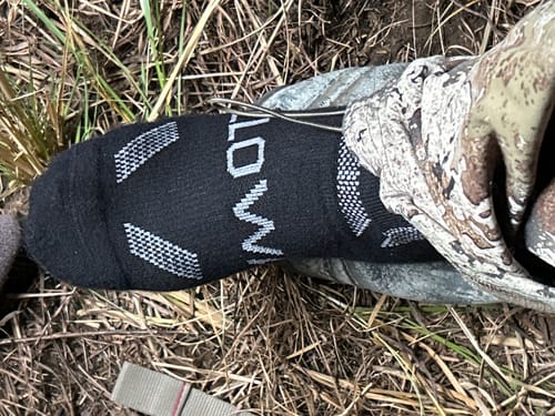 Customer wearing the black Men's Alpaca Socks outdoors while on a deer hunt.