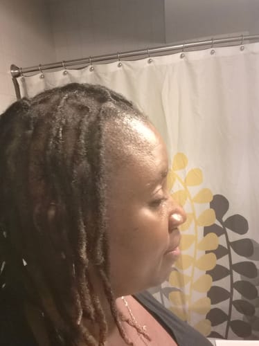Customer's side view of their hydrated, shiny locs after using the Moisturize & Seal Bundle.
