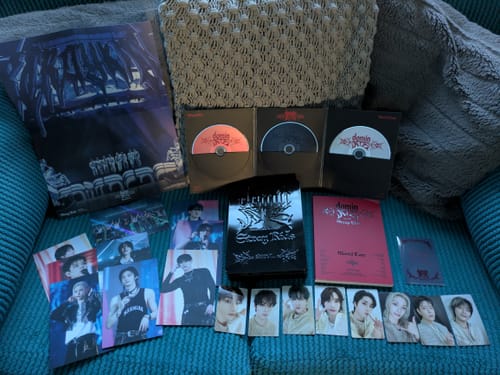 Reviewer's STRAY KIDS dominATE SEOUL DVD set laid out, showing the black tin, three discs, booklets, and multiple photo cards.