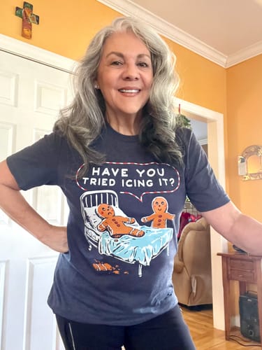 Reviewer smiling while wearing the dark 'Have You Tried Icing It' Tee, showing off its comfortable fit and fun graphic.
