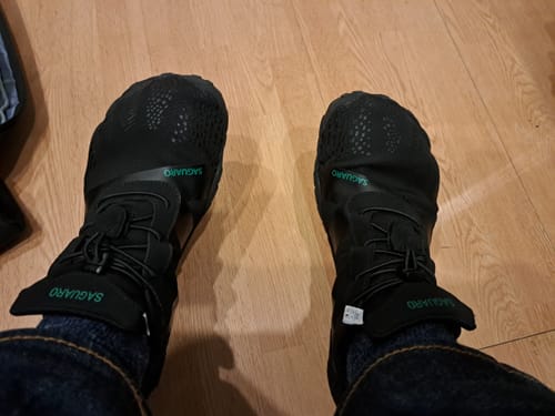 Customer's view looking down at their black Vitality III - Barefoot Shoes being worn indoors.