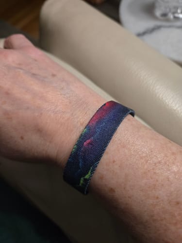 Customer wearing the Shine Through Bracelet, showing its colorful aurora pattern on their wrist.