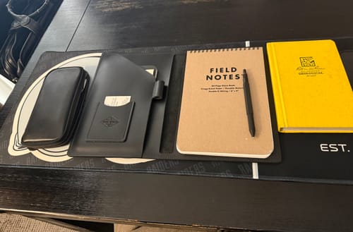 Customer's open black Leather Steno Pad displayed on a desk with a notepad and pen.