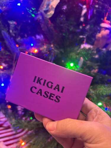 Reviewer holding the purple box packaging for the Nano Case in front of a Christmas tree.
