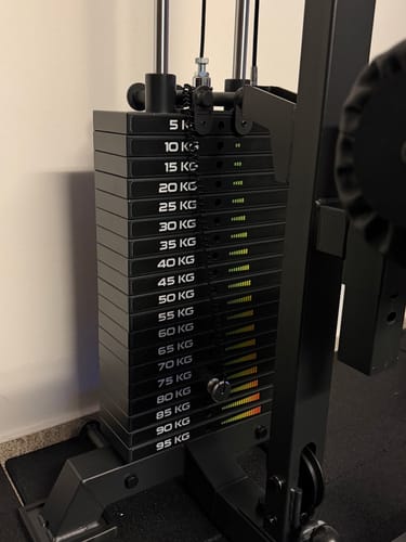 Kunde zeigt den montierten schwarzen Type 1 Top Block 5 kg auf einem Gewichtsstapel an einem Fitnessgerät.