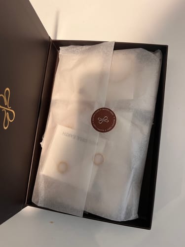 Customer's opened Jewelry For The Dreamers Box, showing contents wrapped in white tissue paper.