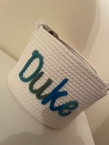 Customer's white Personalized Knitted Basket with the name 'Duke' in multicolored yarn.