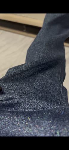 Reviewer's close-up of the Judy Blue Sparkle Flare Jeans, showing the glitter thread detail in the dark fabric.
