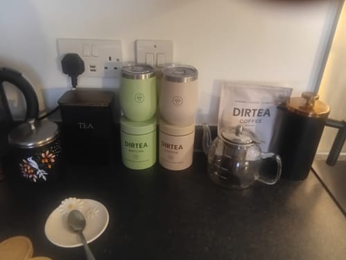 Customer's DIRTEA Coffee pouch and tin displayed on a kitchen counter alongside other DIRTEA products.