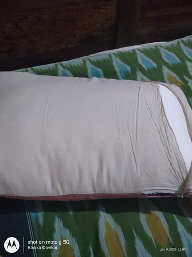 Close-up of the customer's Frido Ultimate Cozy Pillow in a white case on a bed.