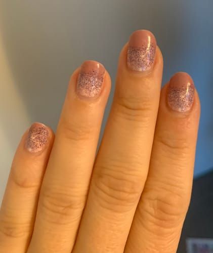 Kundin zeigt ihre Nägel mit den 'Fairytale Wish' Folien, die einen zarten rosa Glitzerverlauf haben.