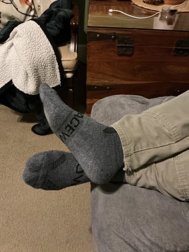 Reviewer relaxing with feet up, wearing the grey Men's Alpaca Socks.