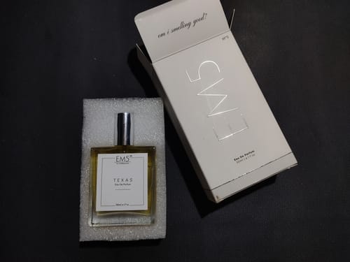 Customer's Texas Eau De Parfum bottle resting in its foam packaging next to the open white product box.