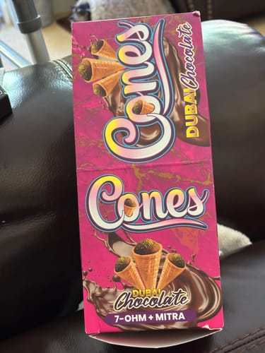 Customer's pink box of Kratom Cones featuring chocolate graphics and product branding.