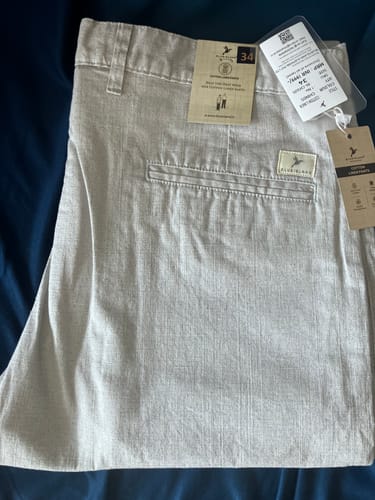 Customer's off-white Cotton Linen Pants shown close-up with original brand tags attached.