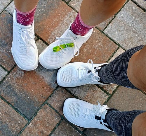 Customer's feet wearing CUURT Muuv wide toe box court shoes on a brick-style patio.